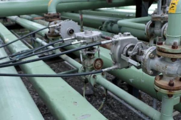 Primo piano di due stazioni valvola con cavi flessibili collegati su tubazioni industriali.