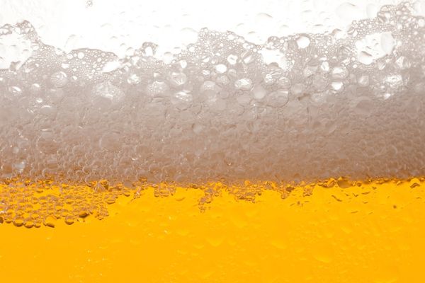 Perché il controllo torbidità della birra è essenziale in ogni birrificio? 3 Primo piano di birra chiara con schiuma, esempio di limpidezza e qualità del prodotto finito